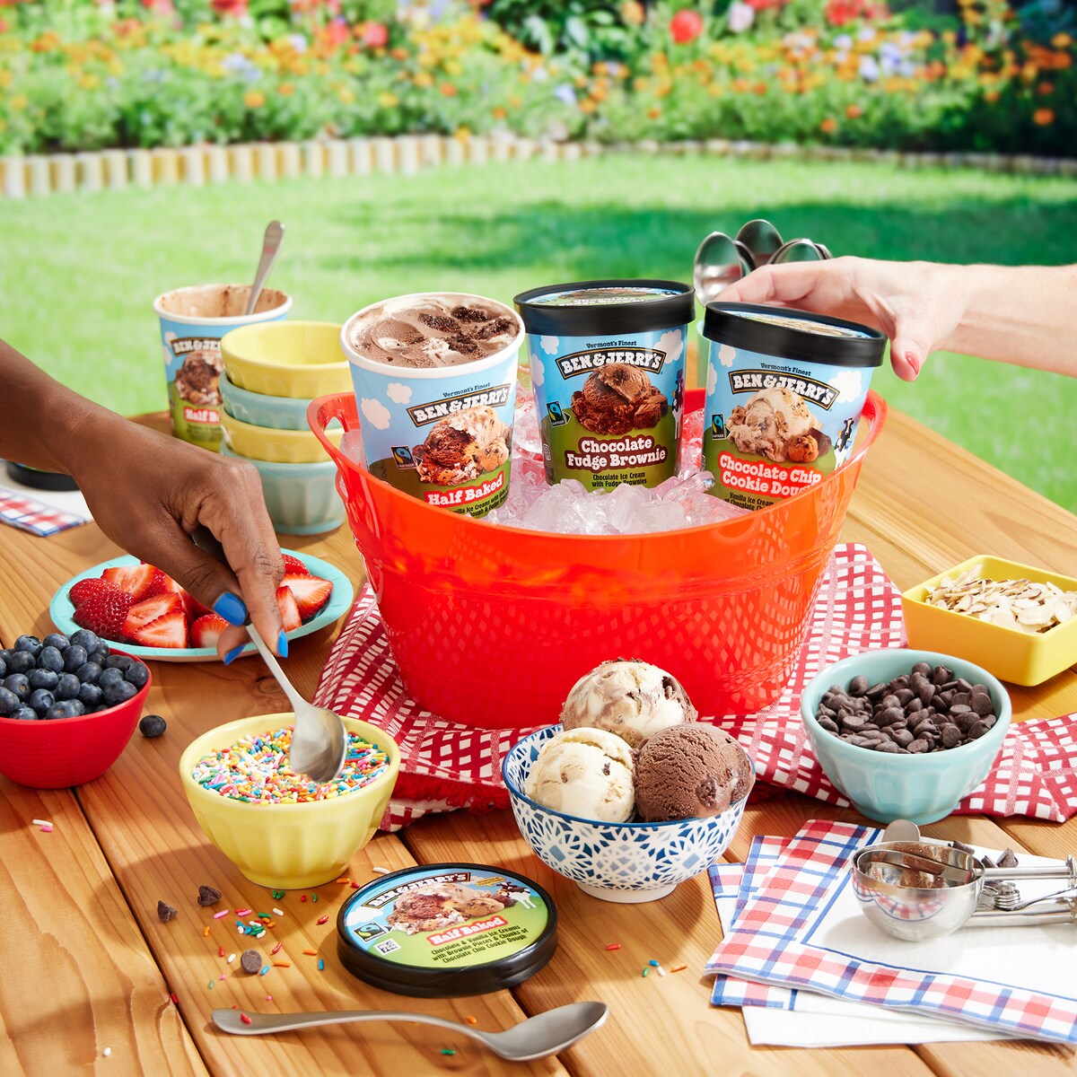 Ben & Jerry's ice cream pints floating in colorful inner tubes in a pool. Cool summer vibes.