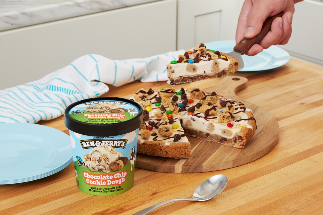 Pint of Ben & Jerry's Chocolate Chip Cookie Dough ice cream next to a pizza made of cookie topped with ice cream and toppings.