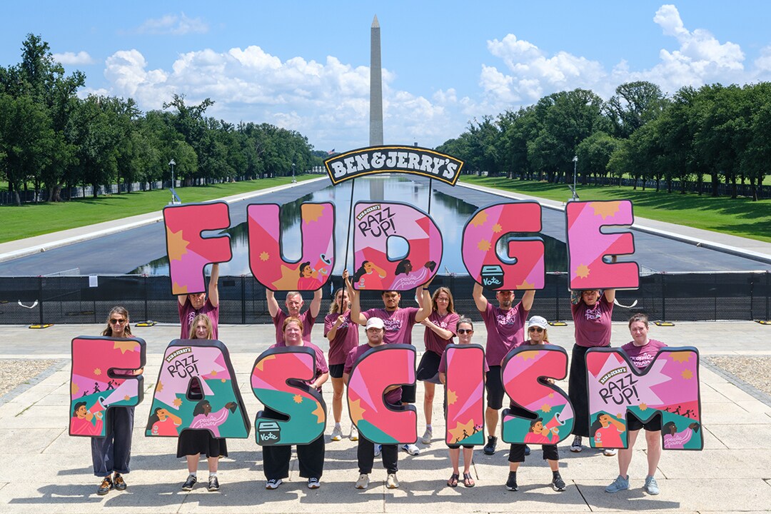 People holding letters that read FUDGE FASCISM in front of the DC capitol building