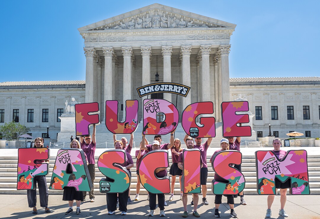 People holding letters that read FUDGE FASCISM in front of the DC capitol building