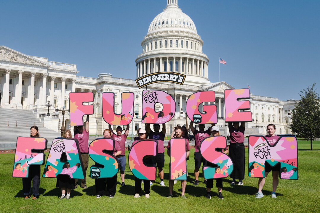 People holding letters that read FUDGE FASCISM in front of the DC capitol building