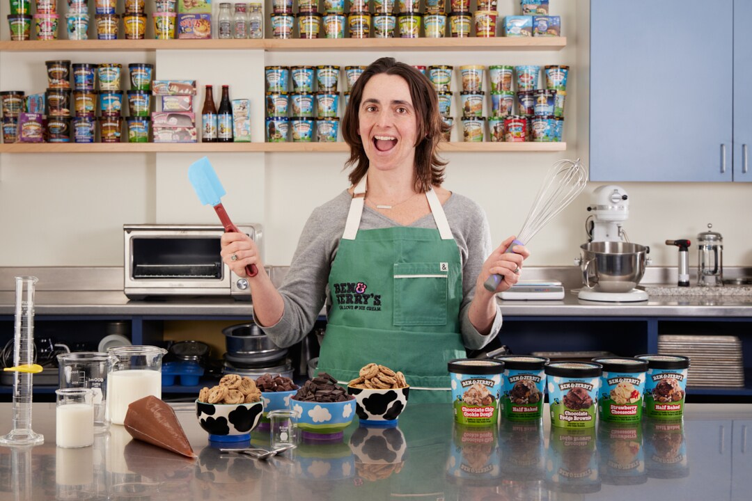 Ben & Jerry's Flavor Guru Sarah Fidler in the Ben & Jerry's test kitchen surrounded by pints of ice cream.