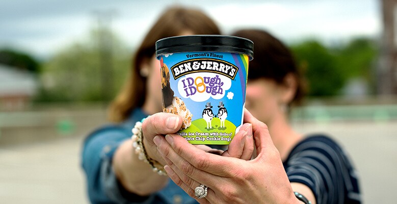 A couple holding up a pint of IDough, Idough ice cream