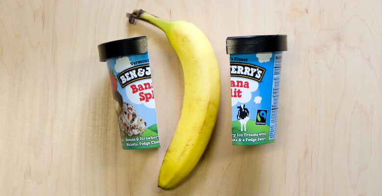 A pint of Banana Split Ben & Jerry's ice cream cut in half and a banana between them