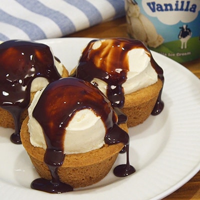 Cookie cups filled with Ben & Jerry's Vanilla ice cream topped with chocolate sauce. Serious yum.