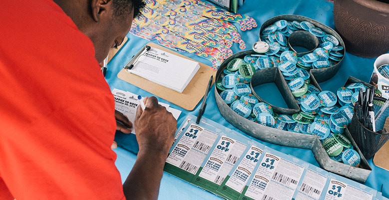 A festival-goer signs a pledge to vote at the Many Rivers to Cross Festival