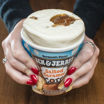Pushing the slightly melted ice cream up out of pint to eat it