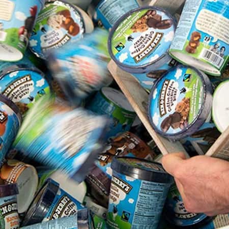 A pile of Ben & Jerry's Ice Cream Pints with more being poured on