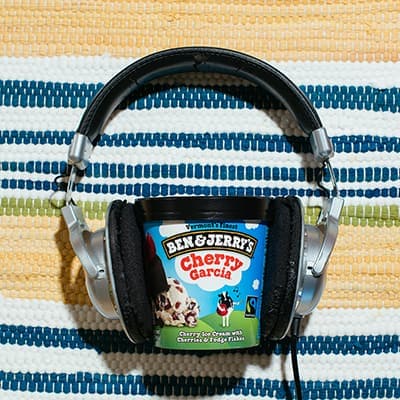 A pint of Cherry Garcia with headphones