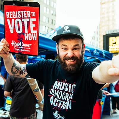 A man with a register to vote today sign