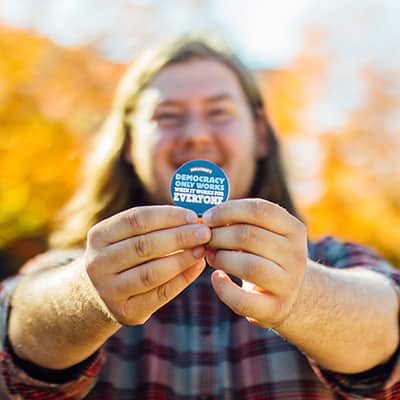 Man holding a button stating he registered