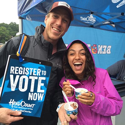 A couple with a register to vote sign