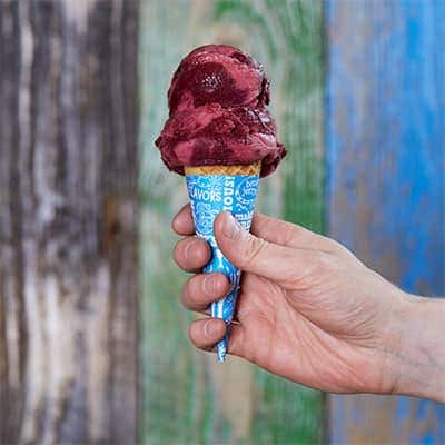 Hand holding cone with Ben & Jerry's Berry Berry Extraordinary sorbet