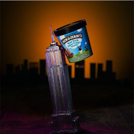 A Pint of Ben & Jerry's New York Super Fudge Chunk with a statue of the Empire State Building