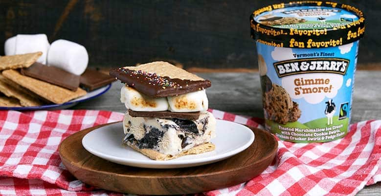 S'mores ice cream sandwich made with a slice of Ben & Jerry's Gimme S'more ice cream next to a pint of Ben & Jerry's Gimme S'more ice cream.